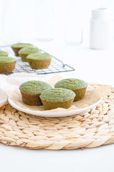 green spinach bannana muffins on a light peach plate